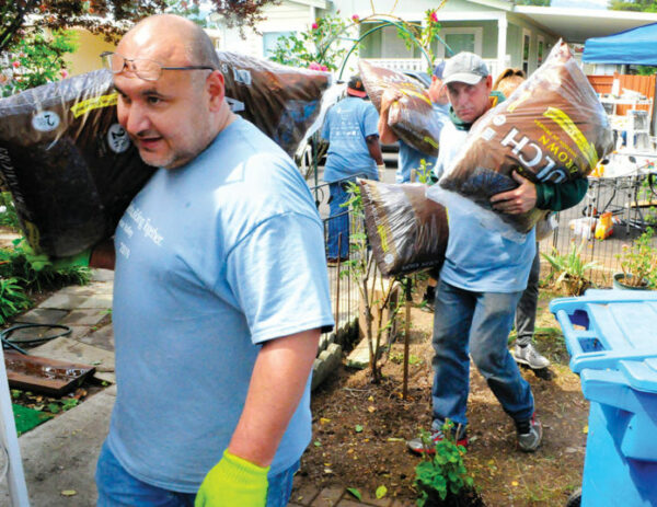 Volunteers bring in mulch for some landscaping work at a home in Pacific Mobile Estates in Gilroy on April 27.